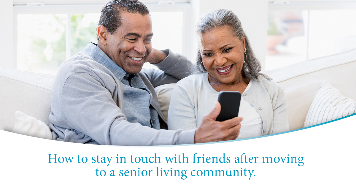How to stay in touch with friends after moving to a senior living community - A man and his wife review on their phone